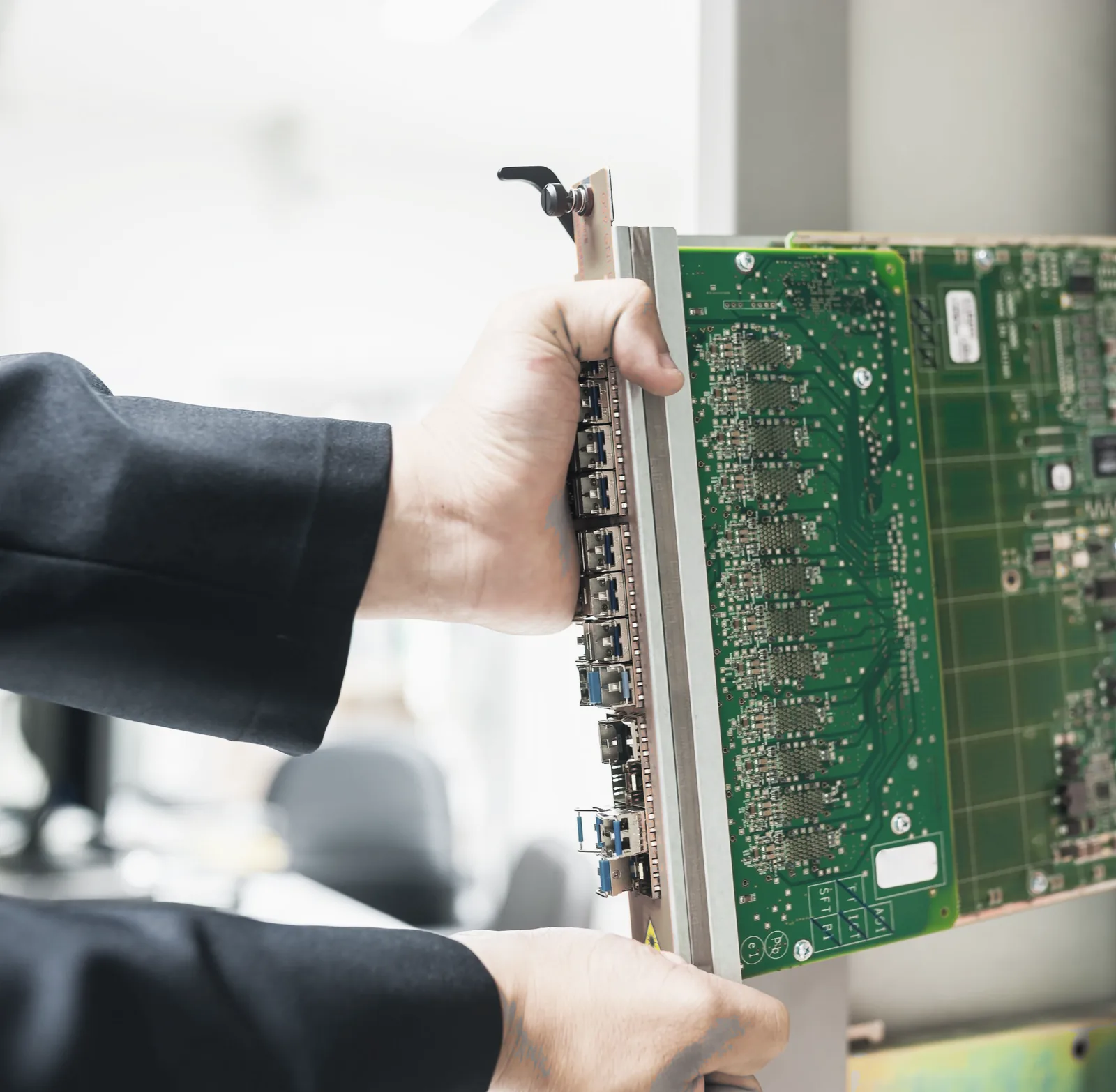 Technik vyměňuje síťový modul v šasi datacentra